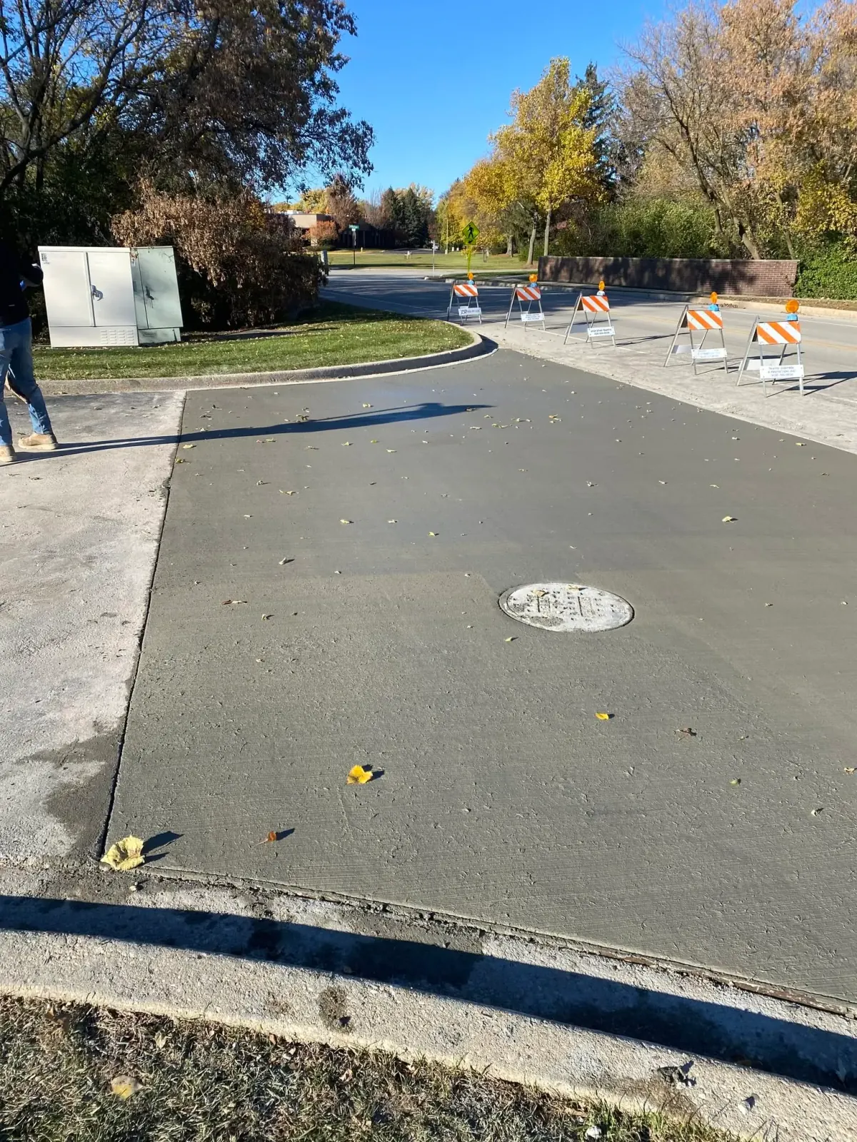 Wide freshly poured concrete apron and driveway with a clean broom finish